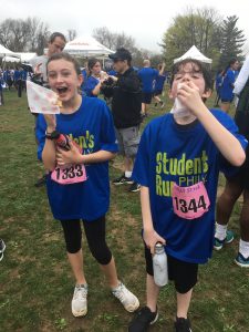 Two students celebrating with snacks after a race