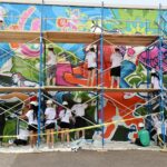 students painting mural on school