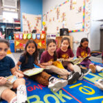 Prek kids on rug with books